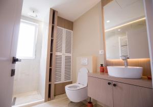 een badkamer met een wit toilet en een wastafel bij Tola Apartaments in Pogradec