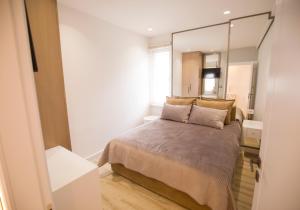 een slaapkamer met een bed en een grote spiegel bij Tola Apartaments in Pogradec
