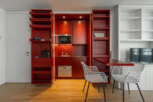 - une cuisine rouge avec une table et des chaises dans l'établissement easy flat Green Prater, à Vienne