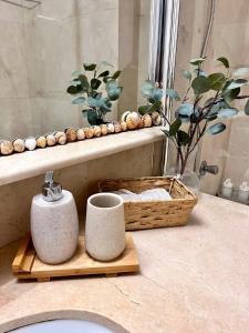 - Baño con lavabo y cesta de toallas en Aquamarine apartment in Marina Sotogrande, en Torreguadiaro