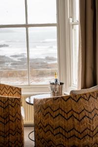 a table and two chairs in front of a window at The Godolphin Hotel in Marazion