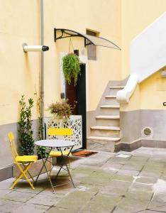 a patio with a table and chairs in front of a building at IN URBS in Salerno +7 photos