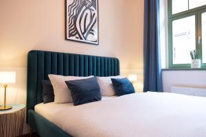 a bedroom with a bed with a green headboard at Hip & Minimalist - Stadt Apartments am Malerweg in Pirna