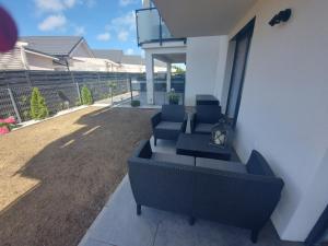 a group of chairs sitting on a patio at Apartament Sarbinowo in Sarbinowo