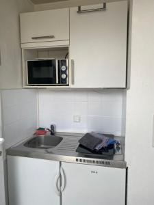 encimera de cocina con fregadero y microondas en Apartmenthaus am Watt Büsum, en Büsum