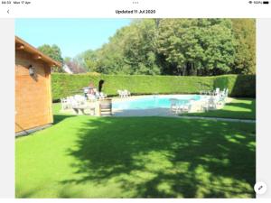 een tuin met een zwembad met witte tafels en stoelen bij Arbor Cottage in Eastbourne