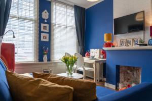 een woonkamer met blauwe muren en een open haard bij Het Kasteeltje in Vlissingen