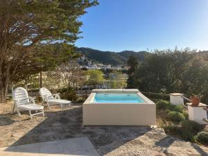 a swimming pool with two chairs and a table at Let's Holidays 7 Xemeneies house in Tossa de Mar