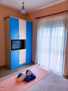 1 dormitorio con armario azul y 1 cama con 2 almohadas en Eleart en Golem