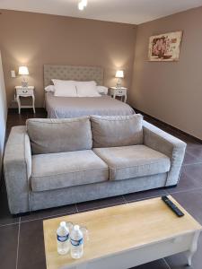 a living room with a couch and a bed at Aux Berges du Canal in Capestang