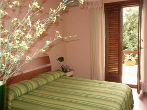 a bedroom with a green bed and a window at La ginestra Chia B&B in Domus de Maria