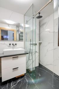 a bathroom with a sink and a glass shower at Apartament Szafirowy z BEZPOŚREDNIM WIDOKIEM na morze- Nadmorski Luksus Apartamenty in Ustronie Morskie