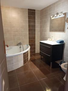 een badkamer met een bad, een wastafel en een toilet bij Aux Berges du Canal in Capestang