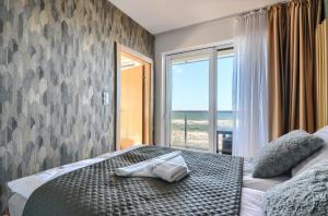 a bedroom with a bed with a view of the ocean at Apartament Szafirowy z BEZPOŚREDNIM WIDOKIEM na morze- Nadmorski Luksus Apartamenty in Ustronie Morskie