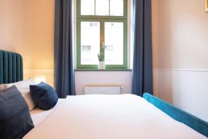 ピルナにあるHip & Minimalist - Stadt Apartments am Malerwegの白いベッドと窓のある寝室