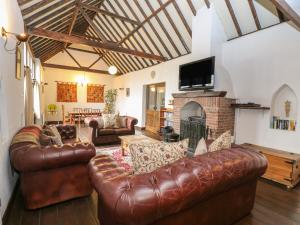 ノリッジにあるThe Old Barnのリビングルーム(革張りのソファ、暖炉付)