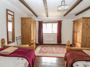 ノリッジにあるThe Old Barnのベッドルーム(ベッド2台、木製キャビネット付)