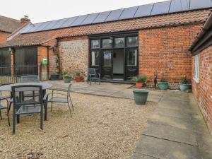ノリッジにあるThe Old Barnの建物の前にパティオ(テーブル、椅子付)