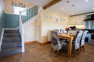 a kitchen and dining room with a table and chairs at Bennar Isa Cottages Dyffryn Ardudwy in Barmouth