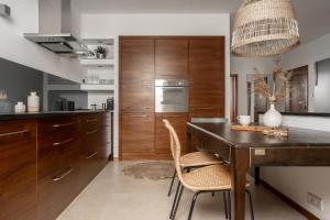 kuchnia z drewnianymi szafkami, stołem i krzesłami w obiekcie APARTAMENT WASILÓWKA ZAKOPANE przy Krupówkach w Zakopanem +1 zdjęcie