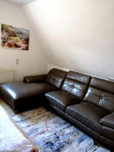 a living room with a brown leather couch at Appartement bei Schloß Ulmerfeld 