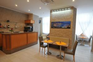 a dining room with a table and a kitchen at Hotel Montecarlo in Milan