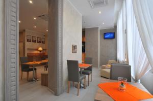 uma sala de jantar com mesas e cadeiras e um sofá em Hotel Montecarlo em Milão
