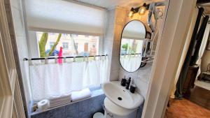 uma casa de banho com um lavatório e um espelho em Rudi4 Luxury Vilnius Apartment em Vilnius