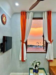 une fenêtre orange et blanche avec vue sur la plage dans l'établissement Rova Hotel Phú Quốc, à Duong Dong