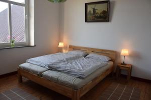 Cette chambre comprend un lit avec deux lampes et une photo murale. dans l'établissement Das Herrenhaus, à Kevelaer