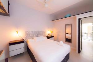 1 dormitorio con 1 cama blanca grande y espejo en Modern apartment in City Centre en Sevilla