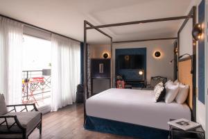 een slaapkamer met een hemelbed en een stoel bij Mom'Art Hotel in Parijs