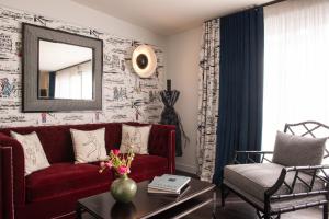 a living room with a red couch and a mirror at Mom'Art Hotel in Paris +28 photos