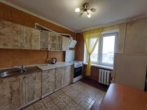 Elle comprend une petite cuisine avec un évier et une fenêtre. dans l'établissement Апартаменти економ, à Loutsk