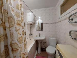 La salle de bains est pourvue d'un lavabo, de toilettes et d'une baignoire. dans l'établissement Апартаменти економ, à Loutsk