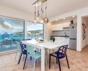 a kitchen and dining room with a white table and chairs at House with pool by the sea - Dugi otok, Žman in Žman
