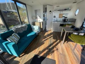 een woonkamer met een blauwe bank en een tafel bij Houseboat Kamperland in Kamperland
