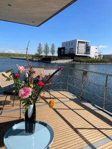 een vaas met bloemen op een tafel op een dek bij Houseboat Kamperland in Kamperland