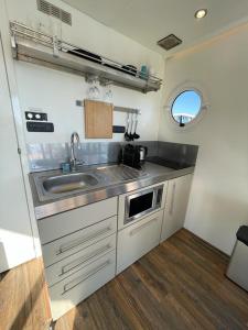 坎珀兰Houseboat Kamperland的带水槽和窗户的小厨房 更多14张照片