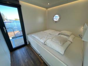 a bed in a small room with a window at Houseboat Kamperland in Kamperland