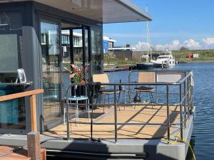 a dock with a table and chairs on a boat at Houseboat Kamperland in Kamperland