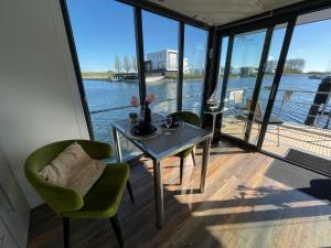 坎珀兰Houseboat Kamperland的水景客房内的桌椅