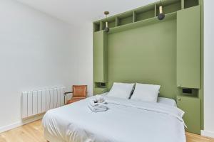 1 dormitorio con 1 cama grande y cabecero verde en Apartment Loft Père Lachaise by Studio prestige, en París