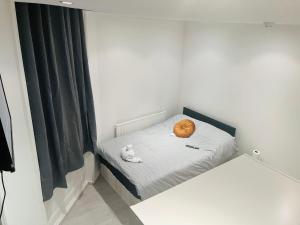 a small room with a bed with a orange ball on it at Y2 guest house in London