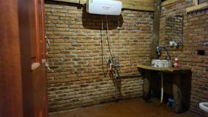 a bathroom with a brick wall and a sink at KONKE RUỘNG FARMSTAY in Kon Von Kla