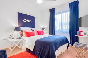アロナにある2 bedrooms appartement with shared pool furnished terrace and wifi at Costa del Silencio 1 km away from the beachのベッドルーム1室(大型ベッド1台、赤と青の枕付)