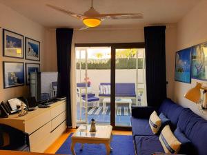 アロナにある2 bedrooms appartement with shared pool furnished terrace and wifi at Costa del Silencio 1 km away from the beachのリビングルーム(青いソファ、テーブル付)