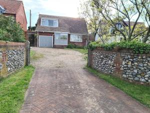 a brick driveway in front of a house at Chalet Bungalow, Little Walsingham in Little Walsingham