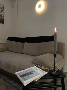 a candle on a table next to a couch at Linkuva Manor Apartment in Kaunas