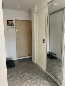 ein leeres Zimmer mit einer Tür und einem Spiegel in der Unterkunft Linkuva Manor Apartment in Kaunas